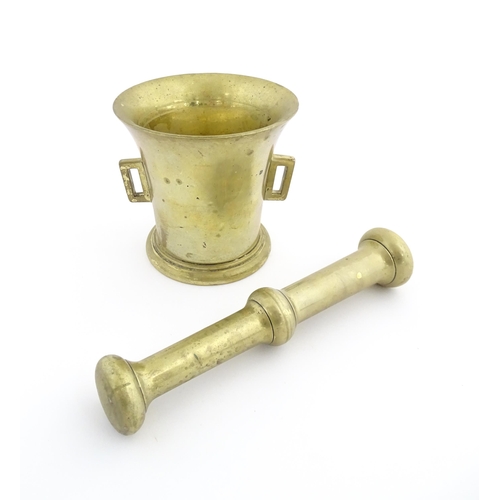 1174 - A 19thC brass pestle and mortar, the mortar of tapering form with twin rectangular handles. Mortar a... 