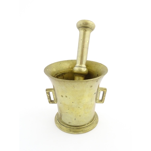 1174 - A 19thC brass pestle and mortar, the mortar of tapering form with twin rectangular handles. Mortar a... 