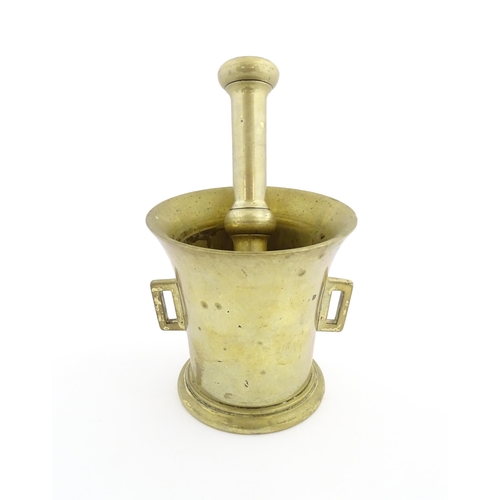 1174 - A 19thC brass pestle and mortar, the mortar of tapering form with twin rectangular handles. Mortar a... 