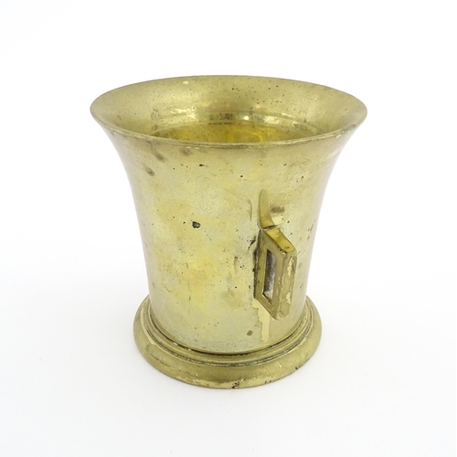 1174 - A 19thC brass pestle and mortar, the mortar of tapering form with twin rectangular handles. Mortar a... 