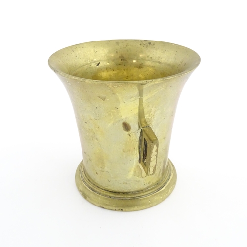 1174 - A 19thC brass pestle and mortar, the mortar of tapering form with twin rectangular handles. Mortar a... 