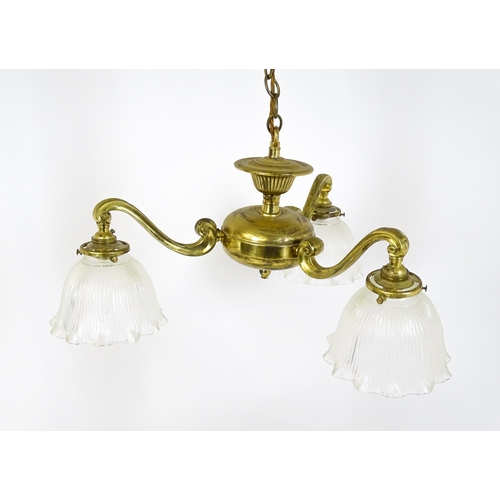 1403 - A pair of brass pendant lights having three scrolling branches with three holophane shades. Approx. ... 