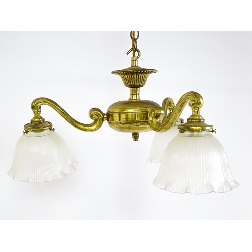 1403 - A pair of brass pendant lights having three scrolling branches with three holophane shades. Approx. ... 