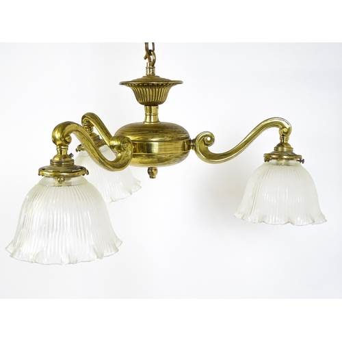 1403 - A pair of brass pendant lights having three scrolling branches with three holophane shades. Approx. ... 