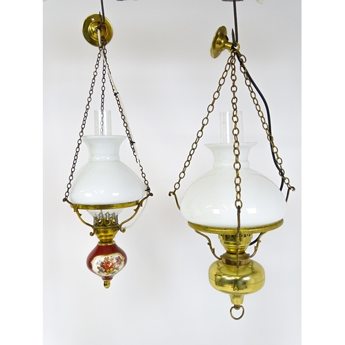 1405 - Two pendant oil lamps one with ceramic reservoir with floral detail. Largest approx. 11