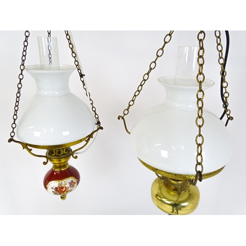 1405 - Two pendant oil lamps one with ceramic reservoir with floral detail. Largest approx. 11