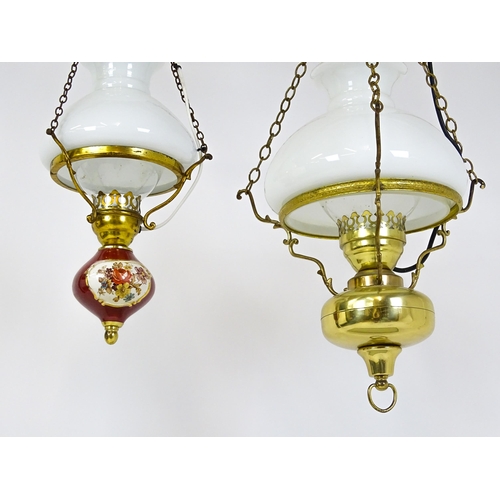 1405 - Two pendant oil lamps one with ceramic reservoir with floral detail. Largest approx. 11