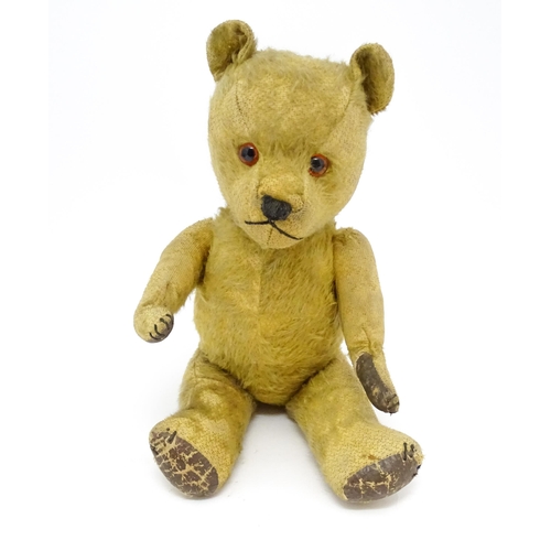 941 - Toy: An early 20thC mohair straw filled teddy bear with stitched nose and mouth, articulated limbs a... 