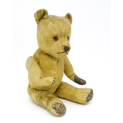 941 - Toy: An early 20thC mohair straw filled teddy bear with stitched nose and mouth, articulated limbs a... 