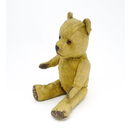 941 - Toy: An early 20thC mohair straw filled teddy bear with stitched nose and mouth, articulated limbs a... 