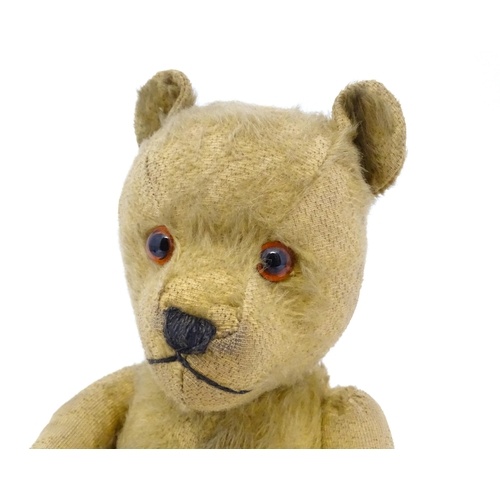 941 - Toy: An early 20thC mohair straw filled teddy bear with stitched nose and mouth, articulated limbs a... 