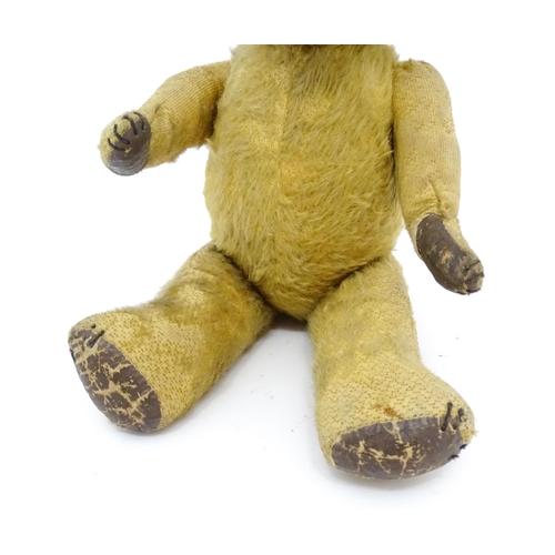 941 - Toy: An early 20thC mohair straw filled teddy bear with stitched nose and mouth, articulated limbs a... 