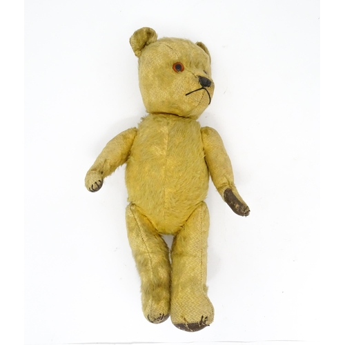 941 - Toy: An early 20thC mohair straw filled teddy bear with stitched nose and mouth, articulated limbs a... 