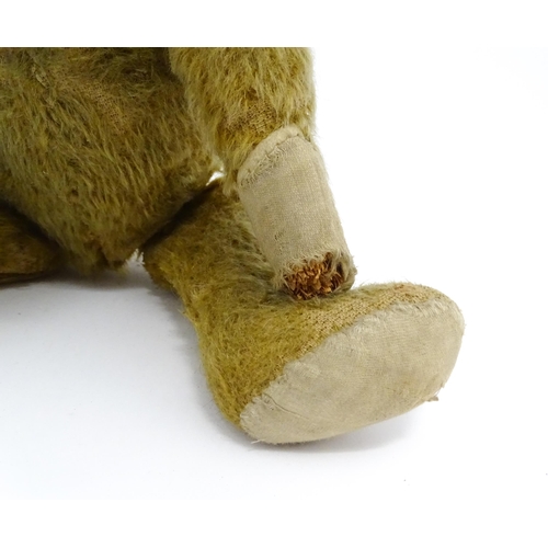 943 - Toy: An early 20thC mohair straw filled teddy bear with proud nose, stitched mouth, hump back, artic... 