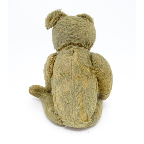 943 - Toy: An early 20thC mohair straw filled teddy bear with proud nose, stitched mouth, hump back, artic... 