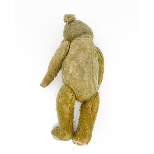 943 - Toy: An early 20thC mohair straw filled teddy bear with proud nose, stitched mouth, hump back, artic... 