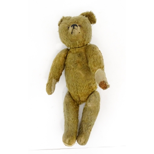 943 - Toy: An early 20thC mohair straw filled teddy bear with proud nose, stitched mouth, hump back, artic... 