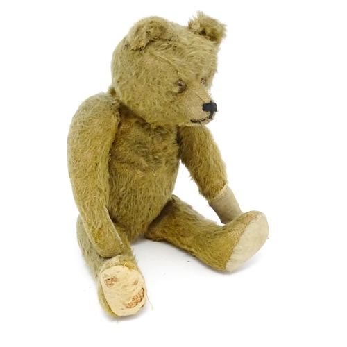 943 - Toy: An early 20thC mohair straw filled teddy bear with proud nose, stitched mouth, hump back, artic... 