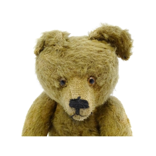 943 - Toy: An early 20thC mohair straw filled teddy bear with proud nose, stitched mouth, hump back, artic... 