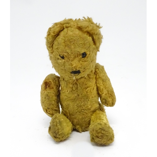 944 - Toy: An early 20thC straw filled teddy bear with stitched nose and articulated limbs. Approx. 7