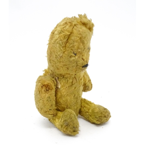 944 - Toy: An early 20thC straw filled teddy bear with stitched nose and articulated limbs. Approx. 7