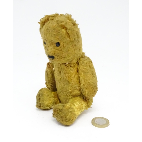 944 - Toy: An early 20thC straw filled teddy bear with stitched nose and articulated limbs. Approx. 7