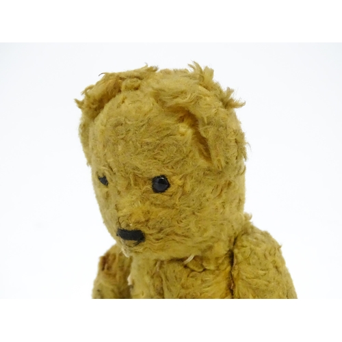 944 - Toy: An early 20thC straw filled teddy bear with stitched nose and articulated limbs. Approx. 7