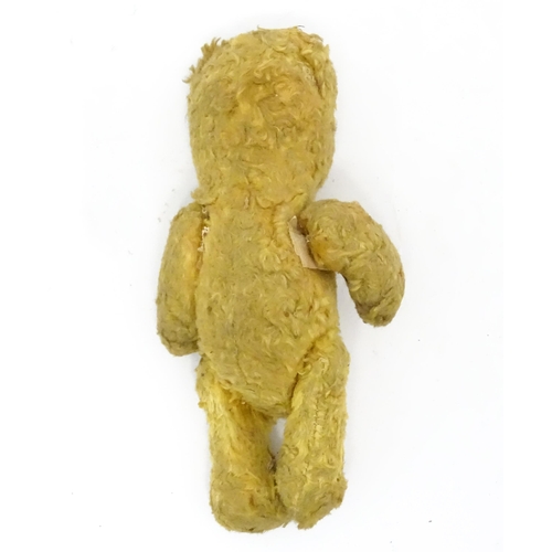 944 - Toy: An early 20thC straw filled teddy bear with stitched nose and articulated limbs. Approx. 7