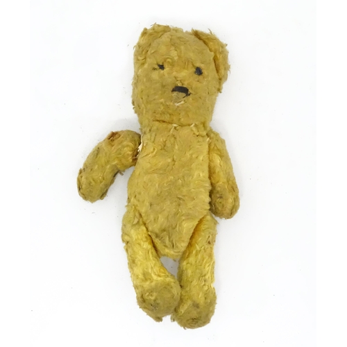 944 - Toy: An early 20thC straw filled teddy bear with stitched nose and articulated limbs. Approx. 7