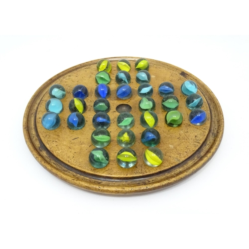 954 - A treen sycamore solitaire board with 32 glass marbles. Board approx. 7 3/4