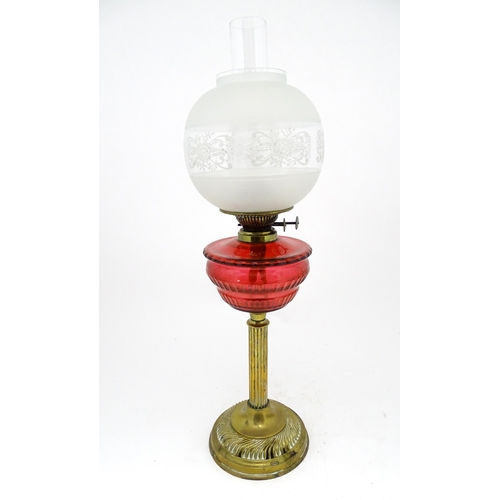 1412 - A late 19th / early 20thC oil lamp with brass column and cranberry glass reservoir with etched glass... 