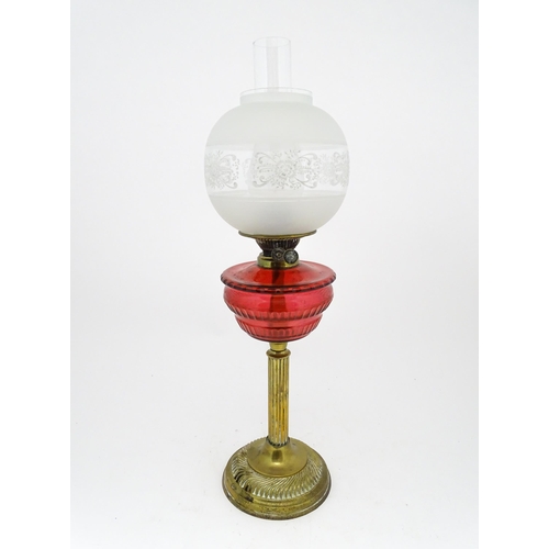 1412 - A late 19th / early 20thC oil lamp with brass column and cranberry glass reservoir with etched glass... 