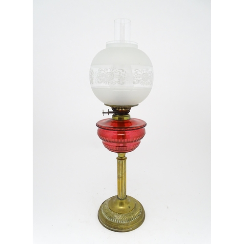 1412 - A late 19th / early 20thC oil lamp with brass column and cranberry glass reservoir with etched glass... 