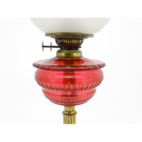 1412 - A late 19th / early 20thC oil lamp with brass column and cranberry glass reservoir with etched glass... 