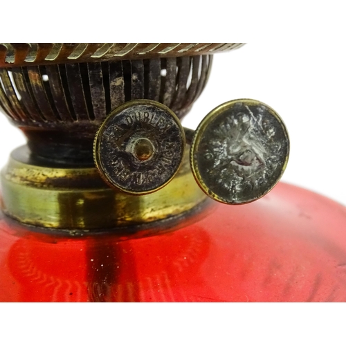 1412 - A late 19th / early 20thC oil lamp with brass column and cranberry glass reservoir with etched glass... 