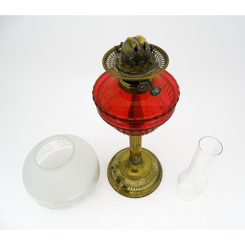 1412 - A late 19th / early 20thC oil lamp with brass column and cranberry glass reservoir with etched glass... 