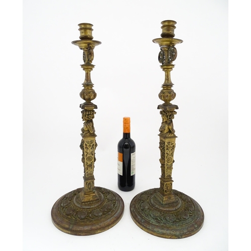 1423 - A pair of 19thC Continental cast brass tall candlesticks with figural, lions mask and foliate detail... 