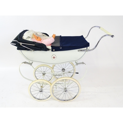 955A - Toys: A 20thC Silver Cross dolls pram with cream exterior. Together with a plastic doll with blinkin... 