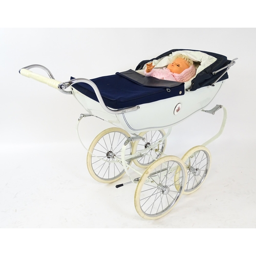 955A - Toys: A 20thC Silver Cross dolls pram with cream exterior. Together with a plastic doll with blinkin... 