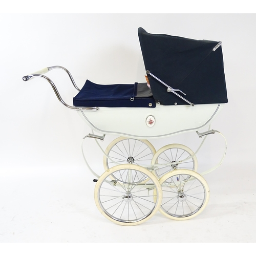 955A - Toys: A 20thC Silver Cross dolls pram with cream exterior. Together with a plastic doll with blinkin... 