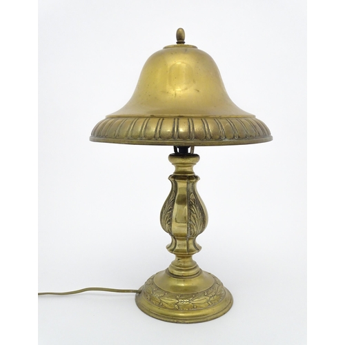 1422 - A 20thC brass table lamp with foliate detail and brass domed shade. Approx. 17