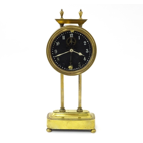 1469 - A brass cased Gravity clock  with dial with Arabic numerals and having exposed escapement. Marked to... 