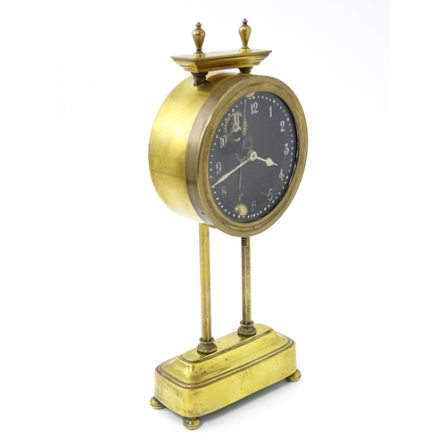 1469 - A brass cased Gravity clock  with dial with Arabic numerals and having exposed escapement. Marked to... 