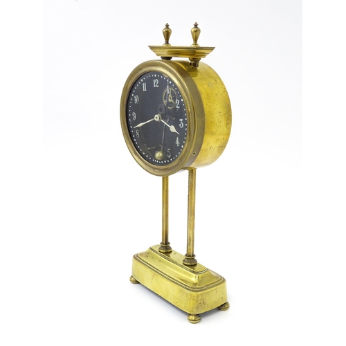 1469 - A brass cased Gravity clock  with dial with Arabic numerals and having exposed escapement. Marked to... 