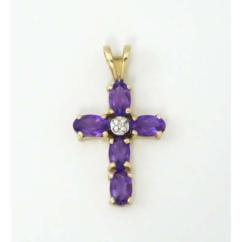 730A - A 9ct gold cross formed pendant set with amethyst and central diamond. Approx. 1