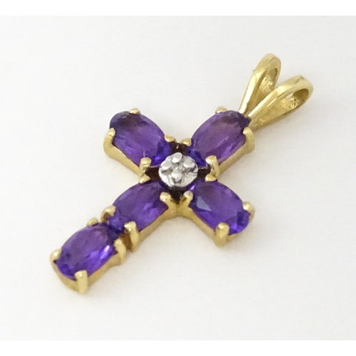 730A - A 9ct gold cross formed pendant set with amethyst and central diamond. Approx. 1