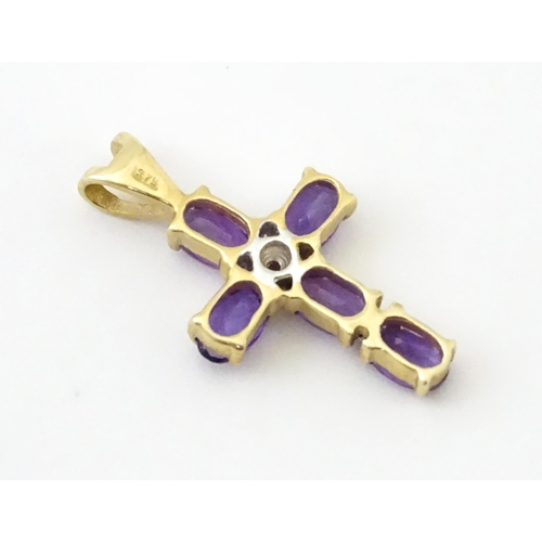 730A - A 9ct gold cross formed pendant set with amethyst and central diamond. Approx. 1