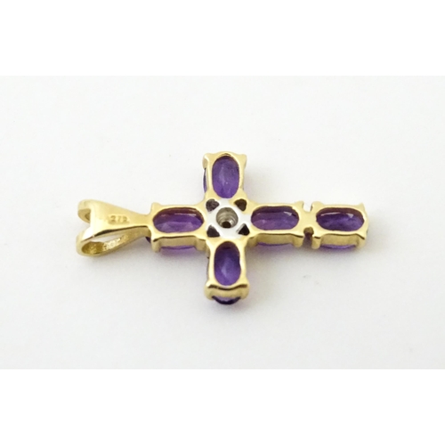 730A - A 9ct gold cross formed pendant set with amethyst and central diamond. Approx. 1