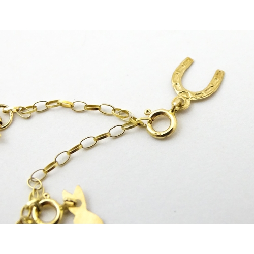 736A - A 9ct gold bracelet set with various charms to include horse shoe, ace of spades, rabbit, etc. Appro... 