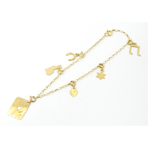 736A - A 9ct gold bracelet set with various charms to include horse shoe, ace of spades, rabbit, etc. Appro... 